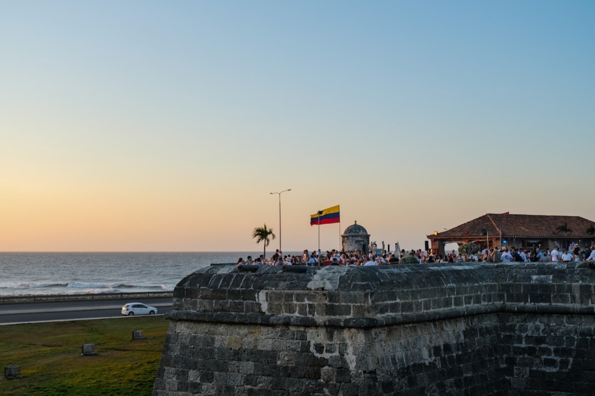 Golden sunset viewed from the historic city walls of Cartagena with people gathered along the ramparts